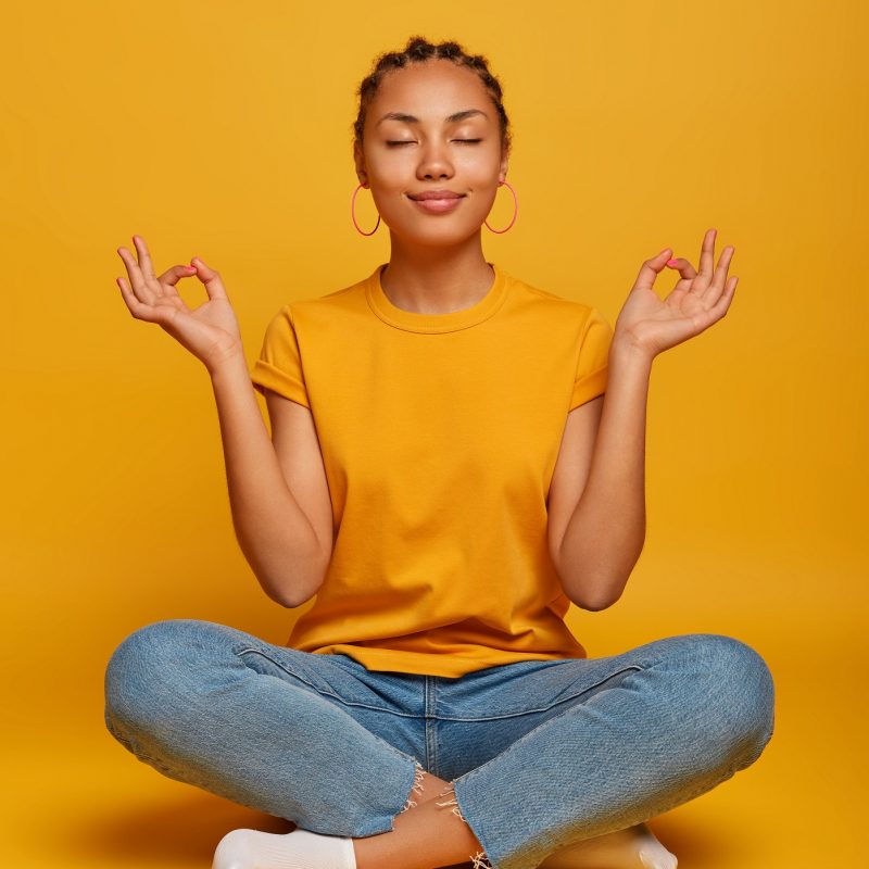 Peaceful,Calm,Dark,Skinned,Female,Model,Sits,Crossed,Legs,On Peaceful,Calm,Dark,Skinned,Female,Model,Sits,Crossed,Legs,On